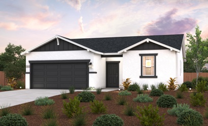 A house with a garage and bushes in front of it.