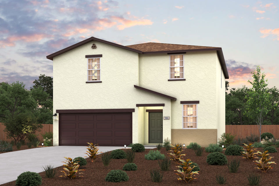 A house with a garage and bushes in front of it.
