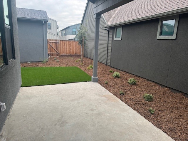 A backyard with a fence and a yard.