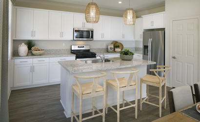 A kitchen with white cabinets.