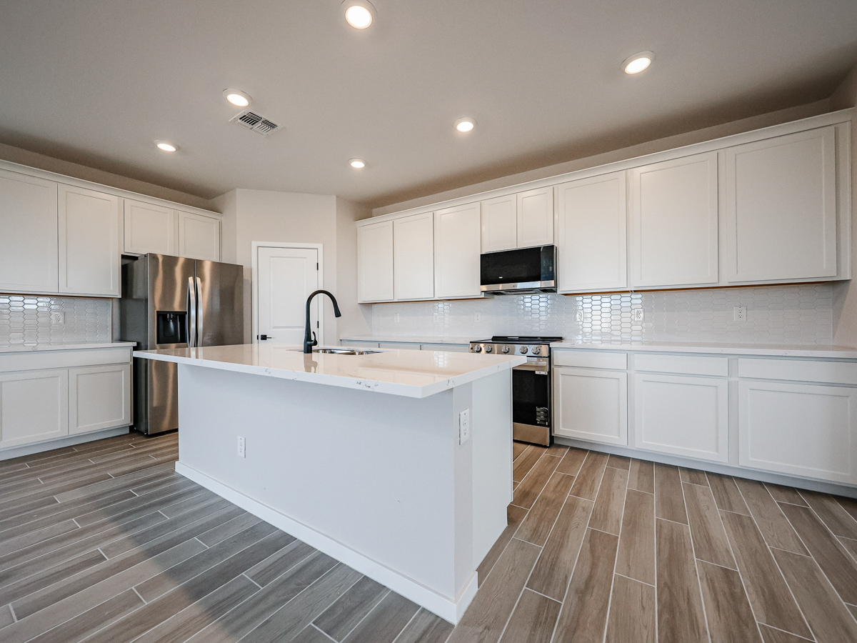 A kitchen with white cabinets.