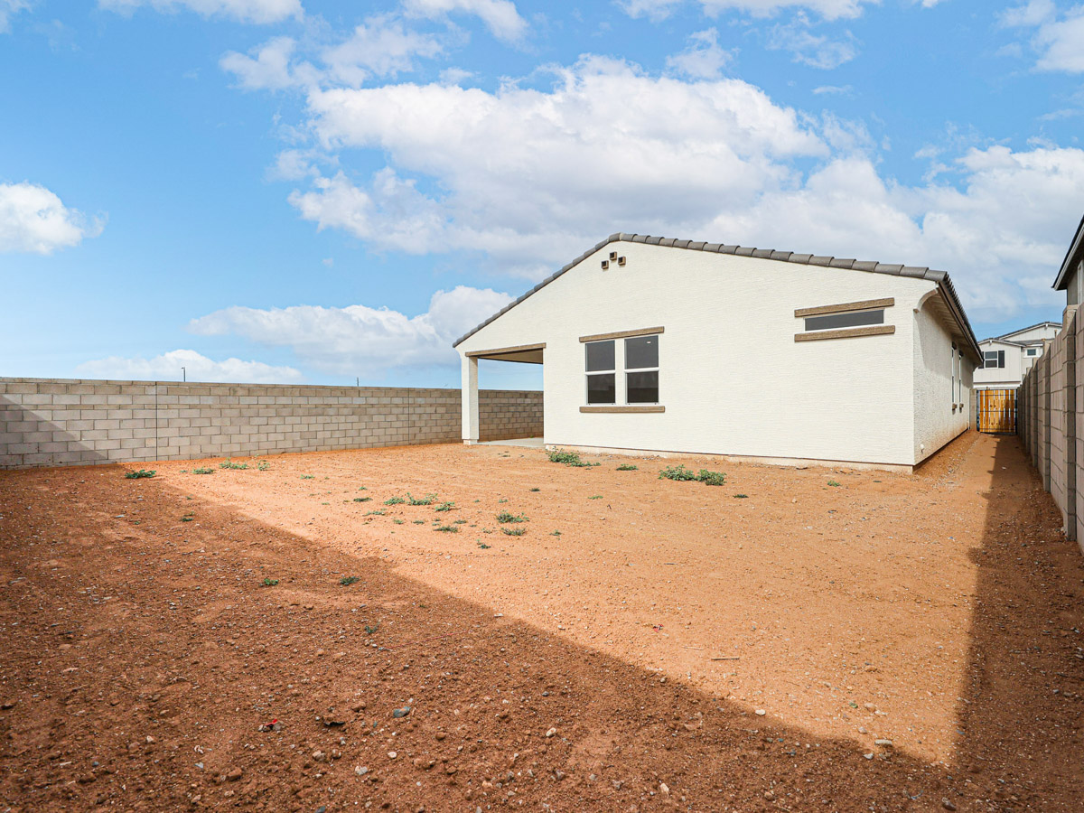 A dirt road leading to a house.