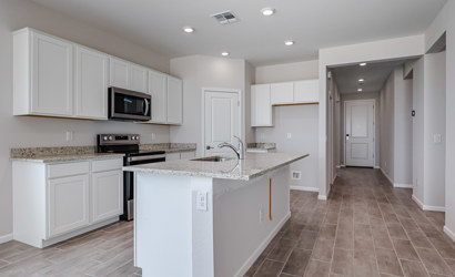 A kitchen with white cabinets.