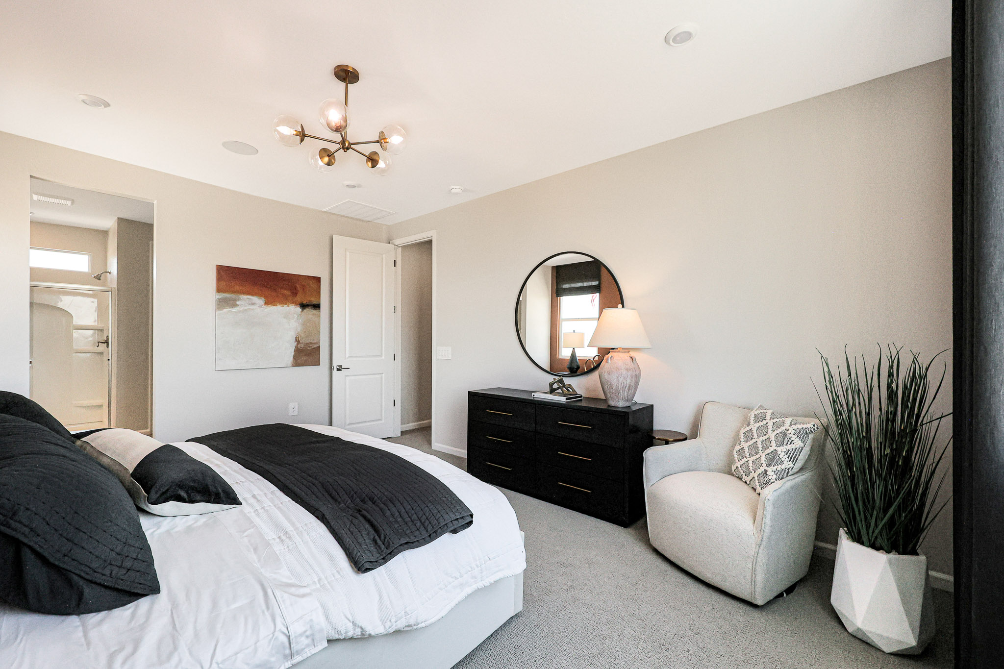 A bedroom with a bed and a chair.