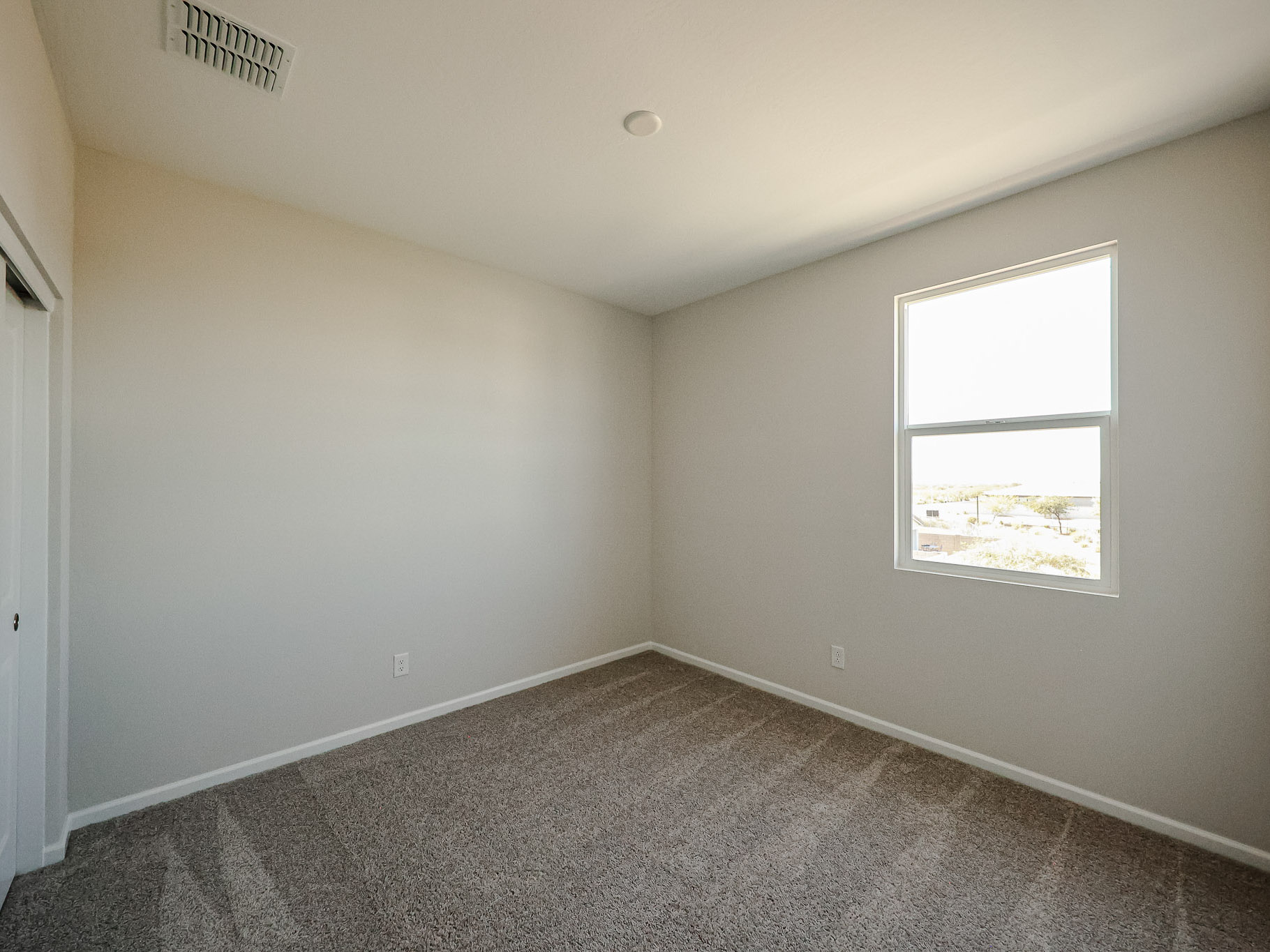 A room with a window and a carpet.