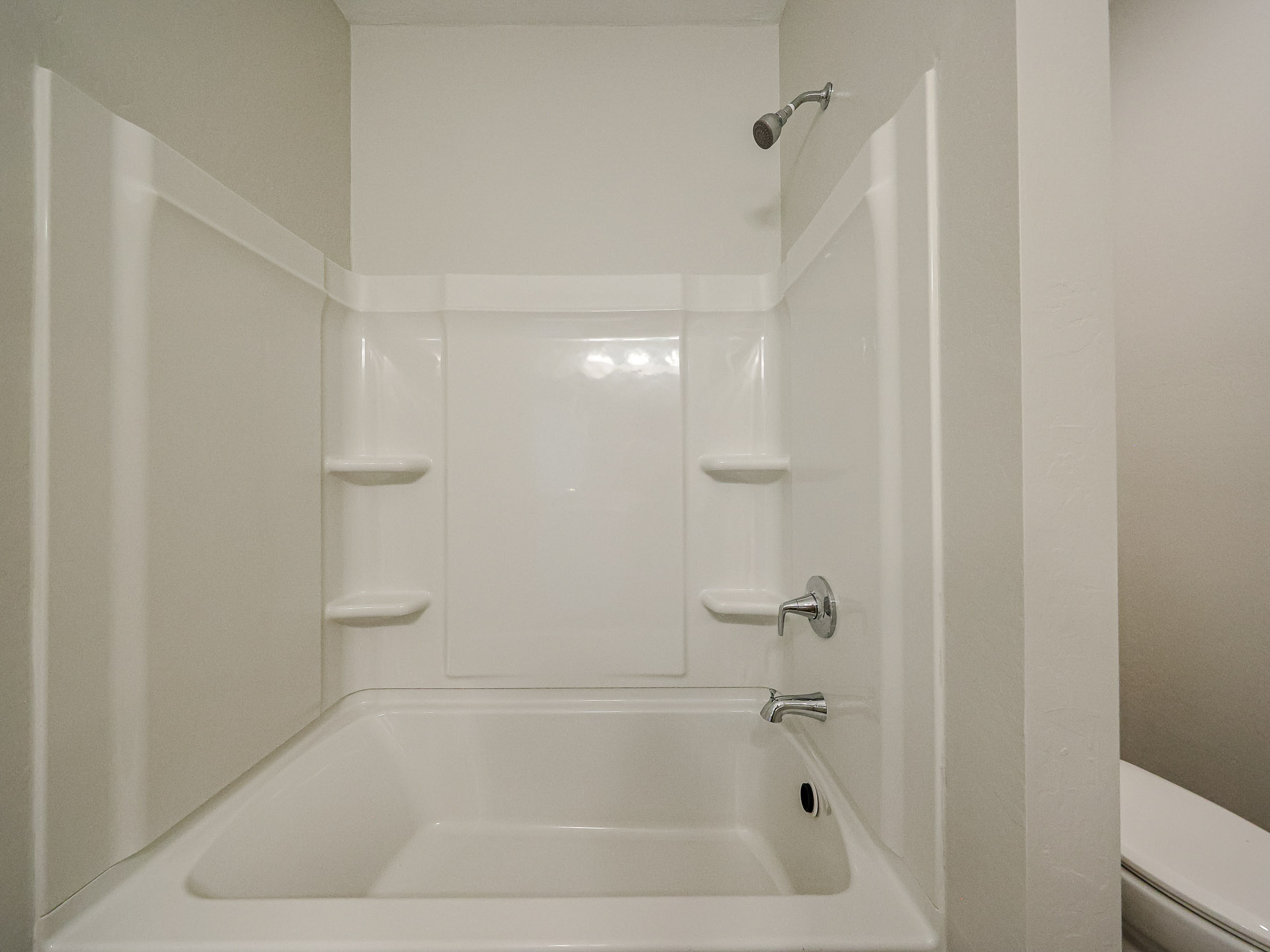 A bathroom with a bathtub and toilet.