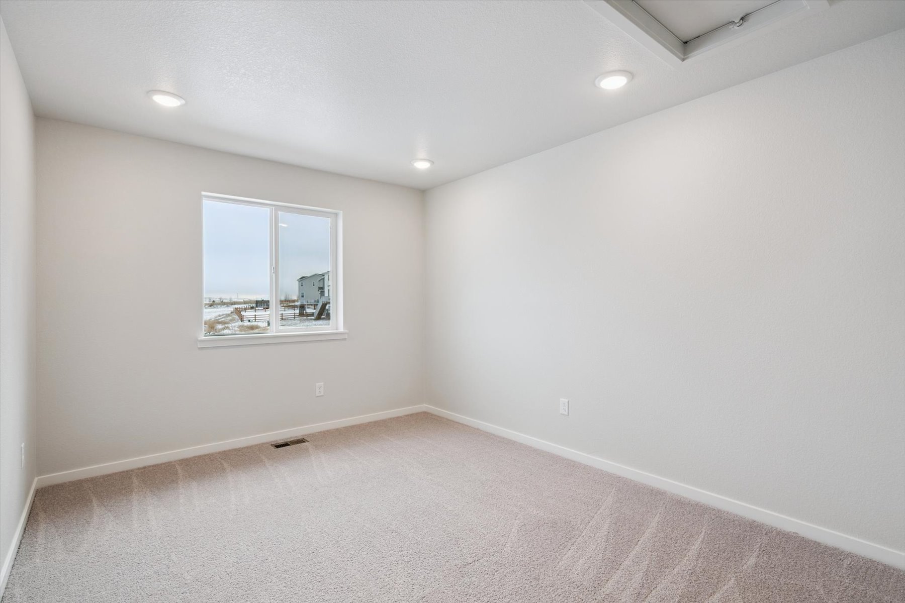 A room with a window and a carpet.