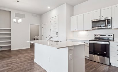 A kitchen with white cabinets.