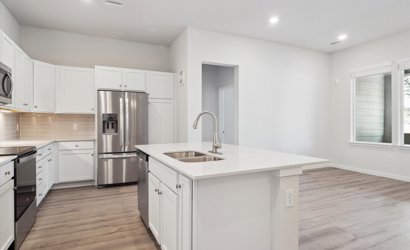 A kitchen with white cabinets.