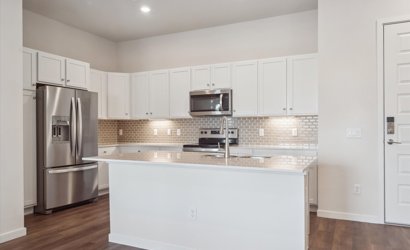 A kitchen with white cabinets.