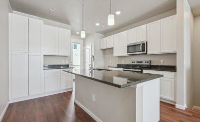 A kitchen with white cabinets.