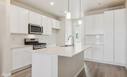 A kitchen with white cabinets.