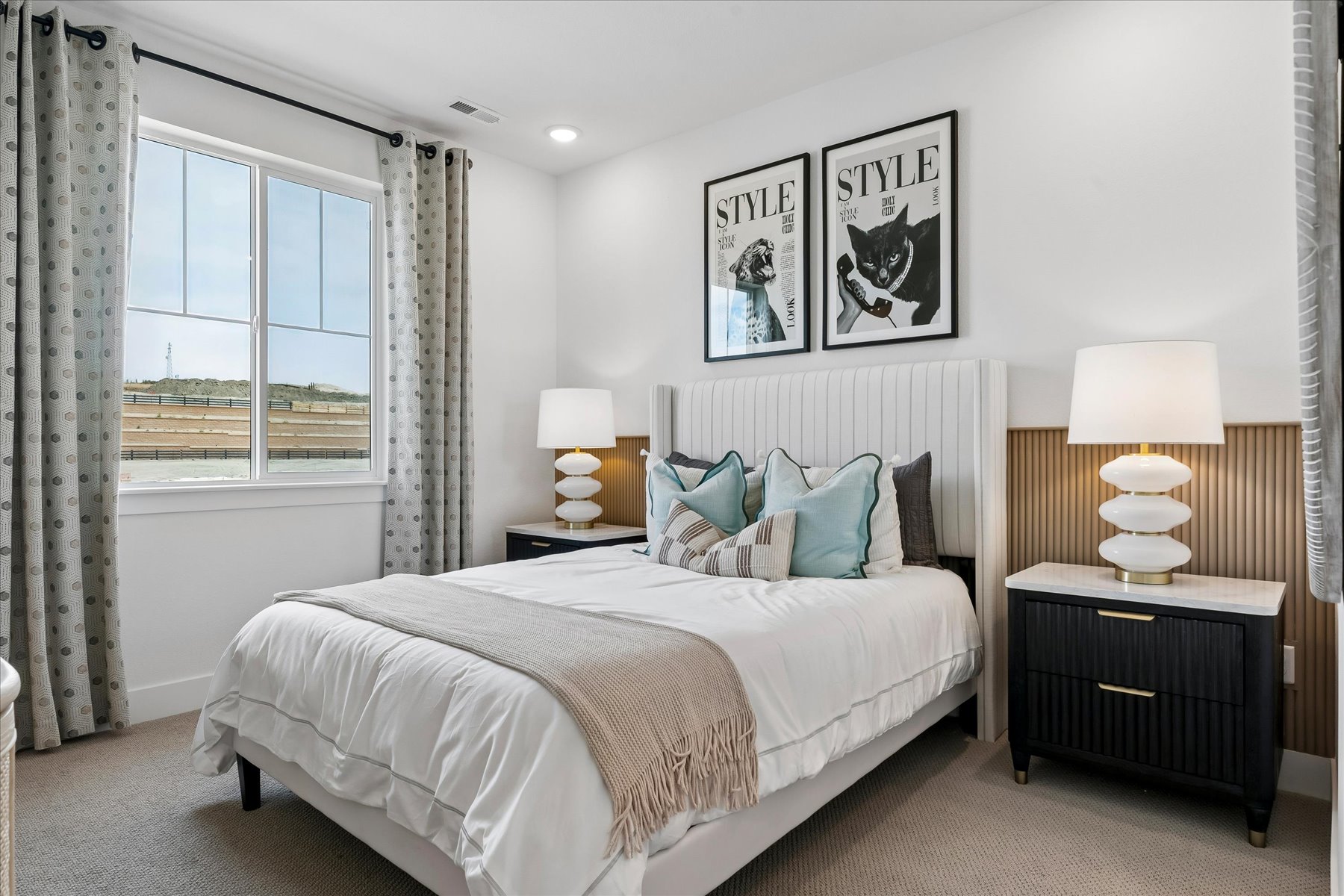 A bedroom with a bed and lamps.