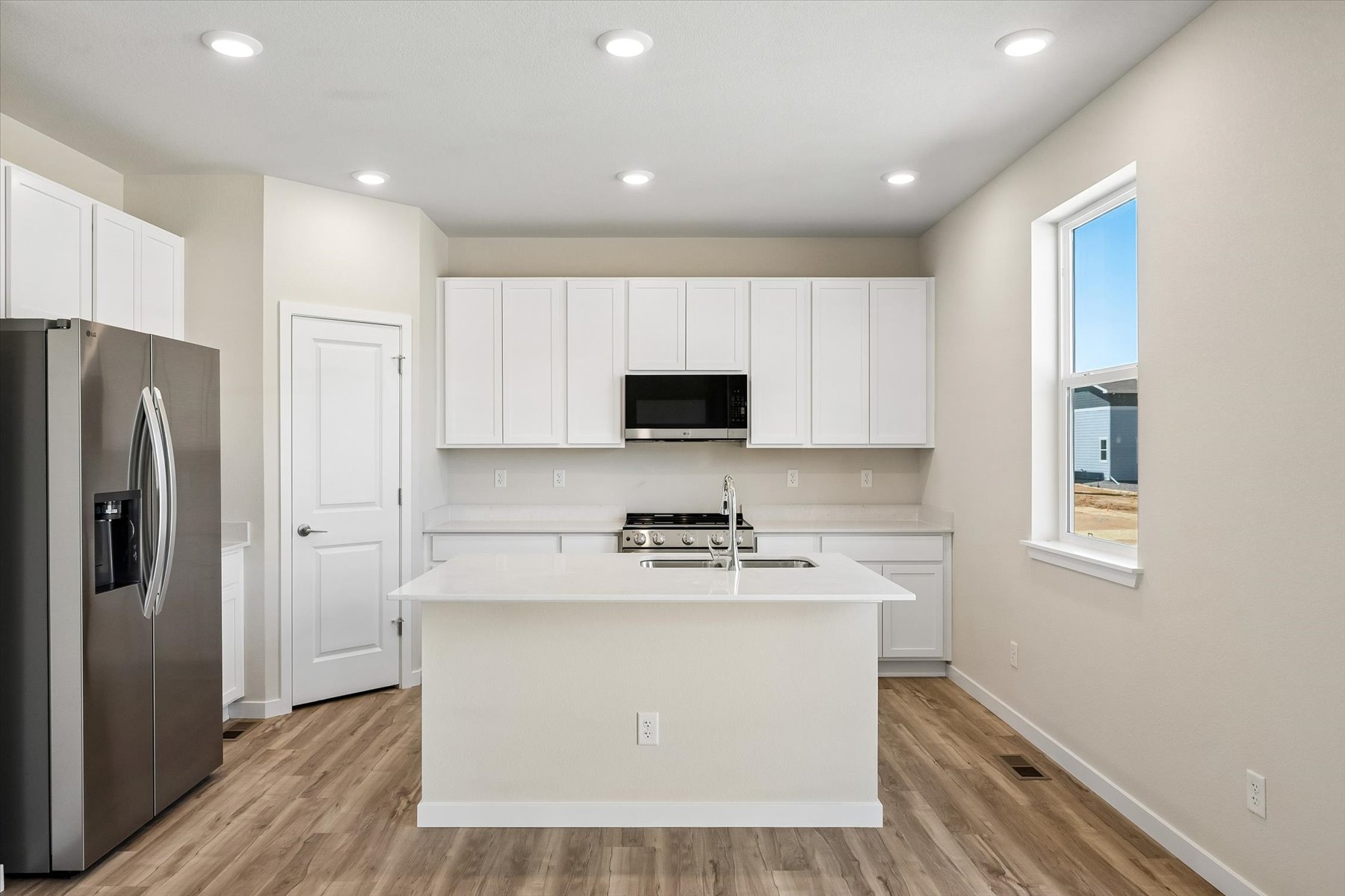A kitchen with white cabinets.