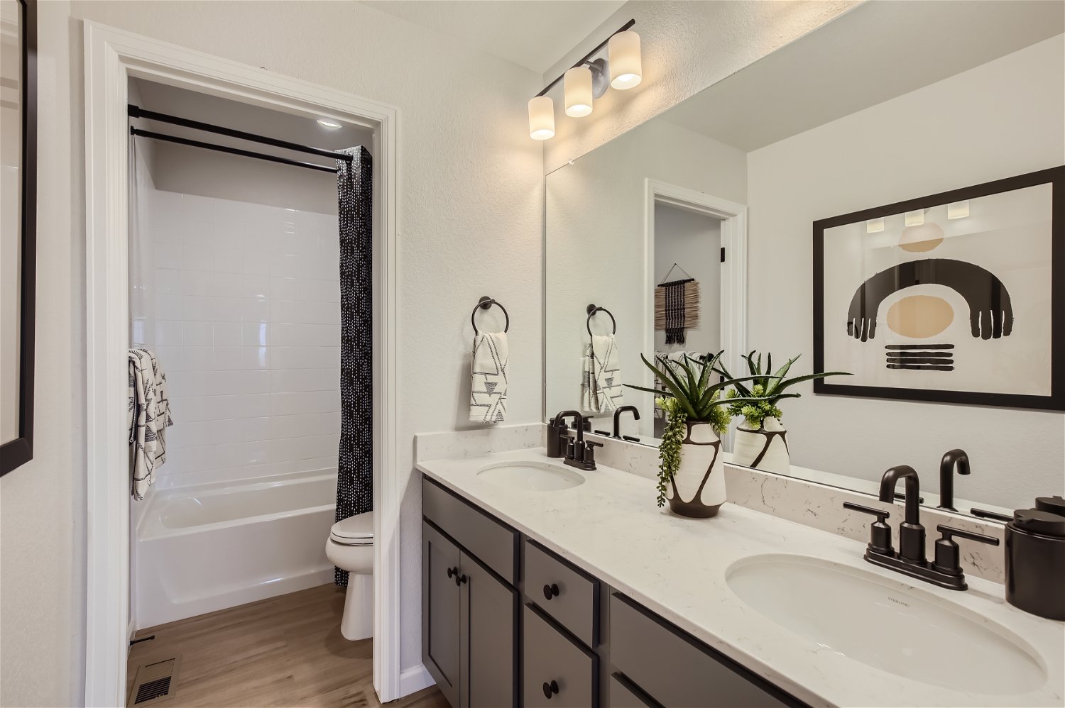A bathroom with a tub sink and mirror.