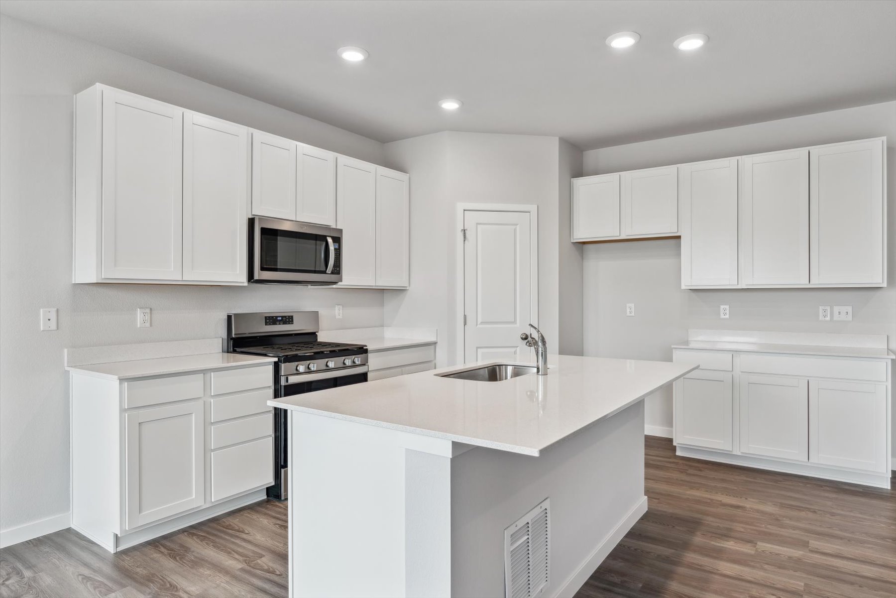 A kitchen with white cabinets.