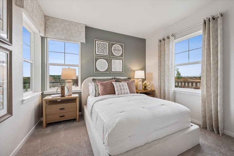 A bedroom with a bed and lamps.