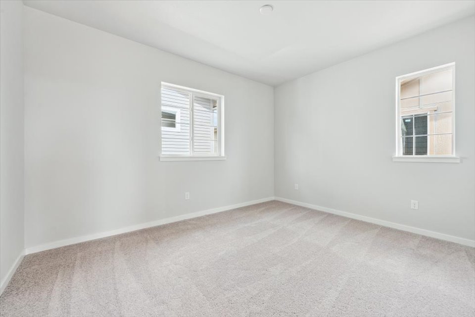 A room with a window and a white wall.