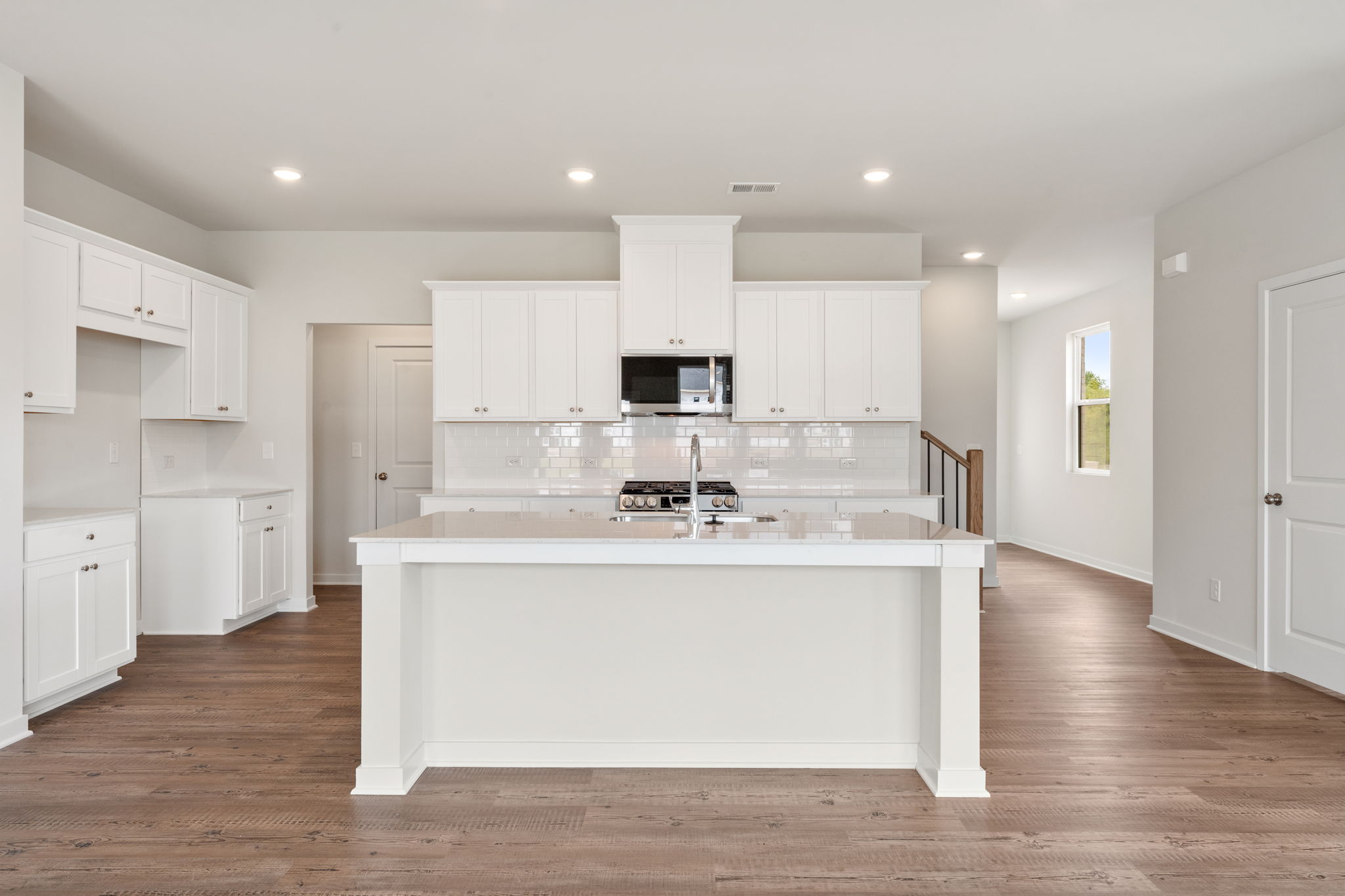 A kitchen with white cabinets.