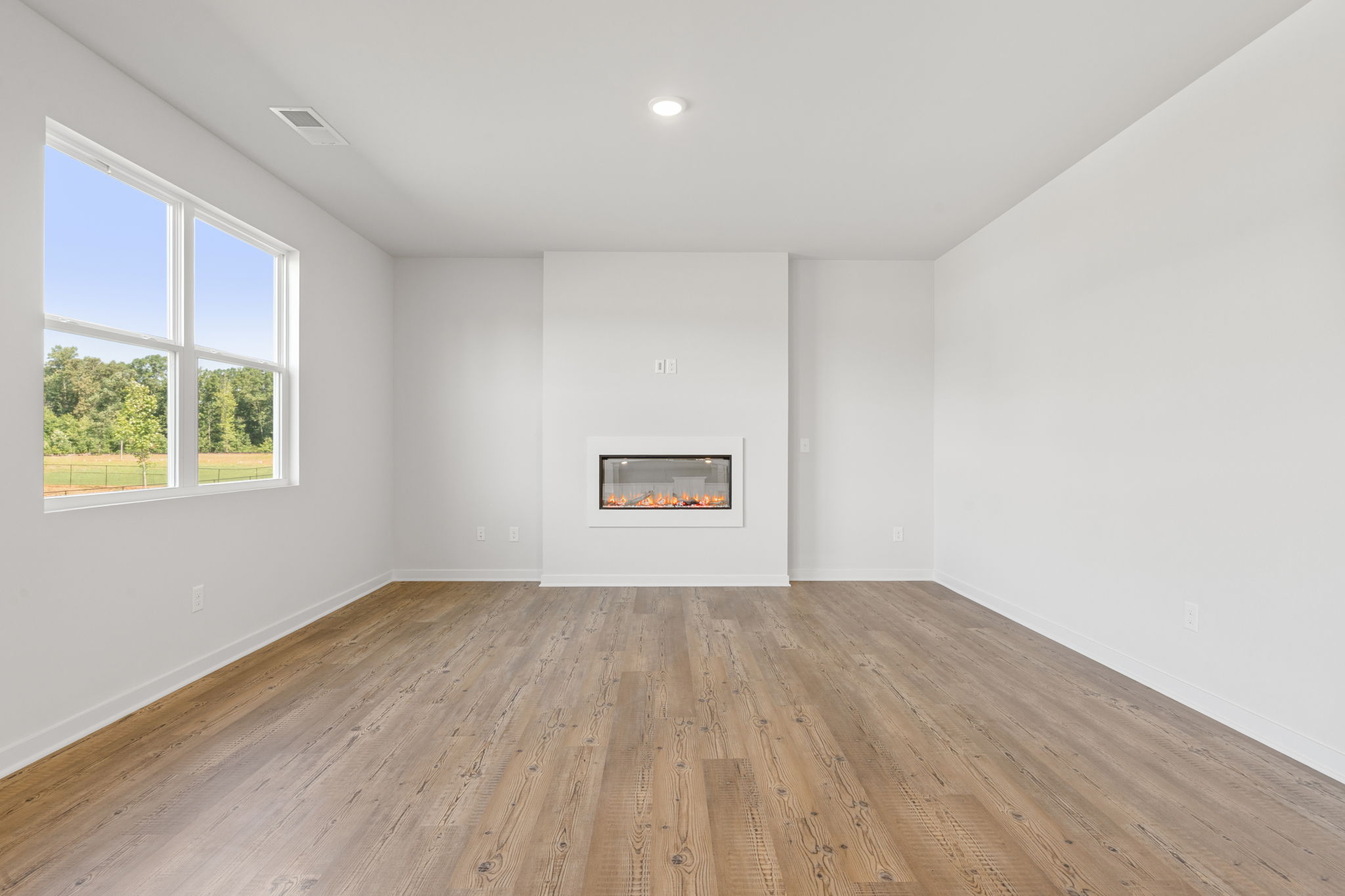 A room with a wood floor and a window with a picture on it.