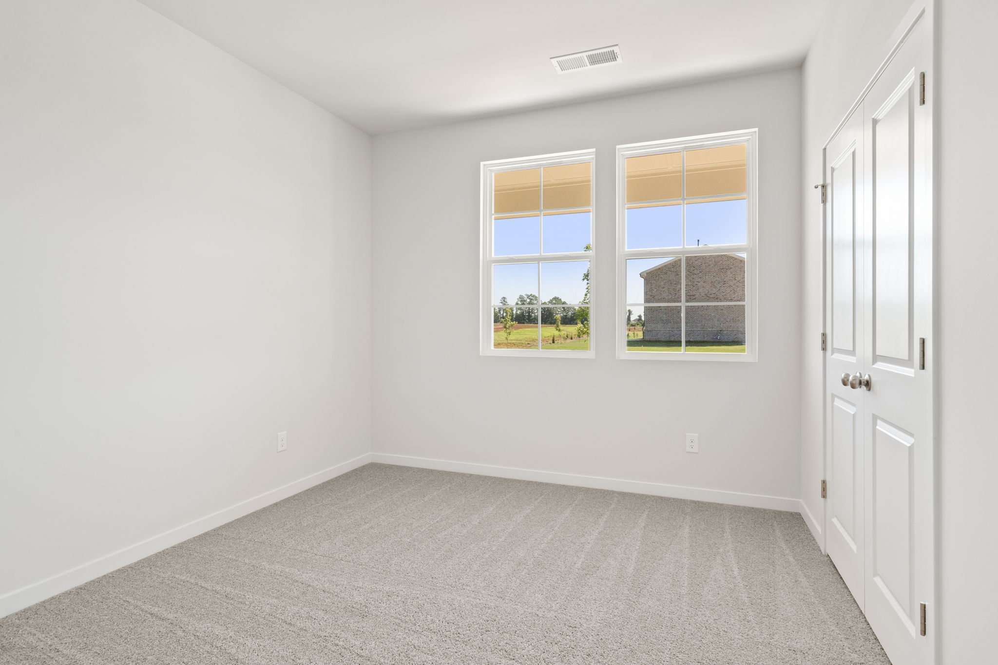 A room with windows and a carpet.