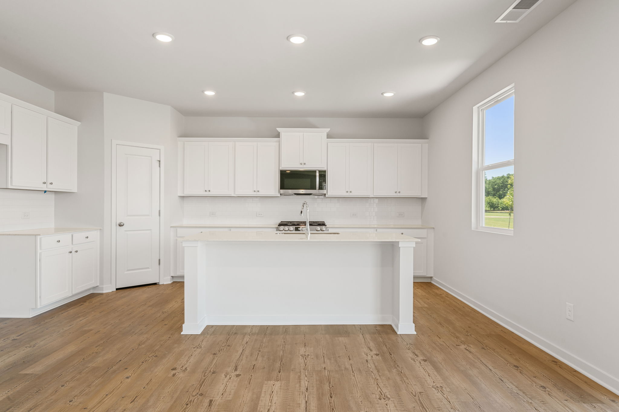 A kitchen with white cabinets.
