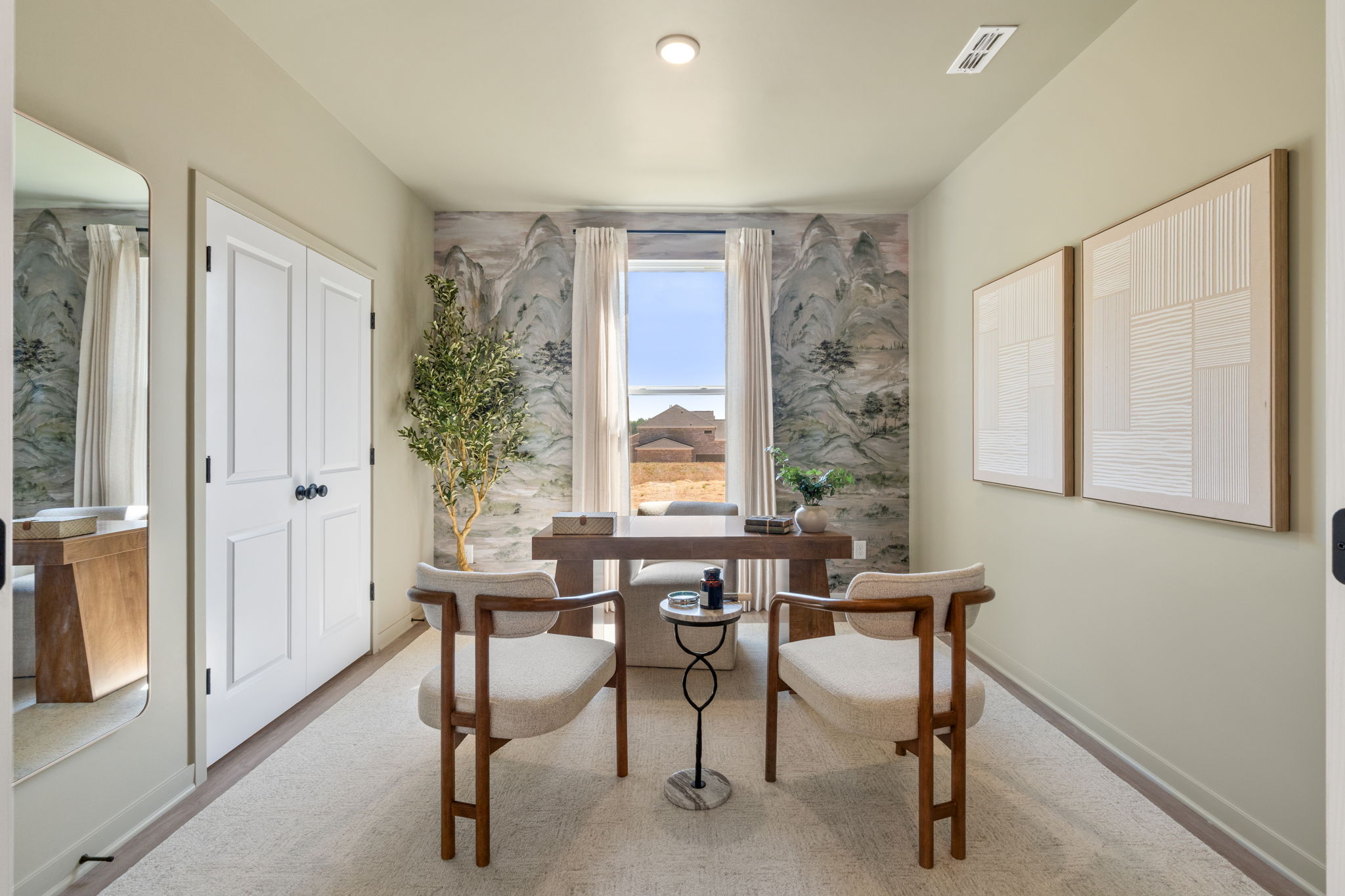 A room with a table chairs and a window with a view of the ocean.