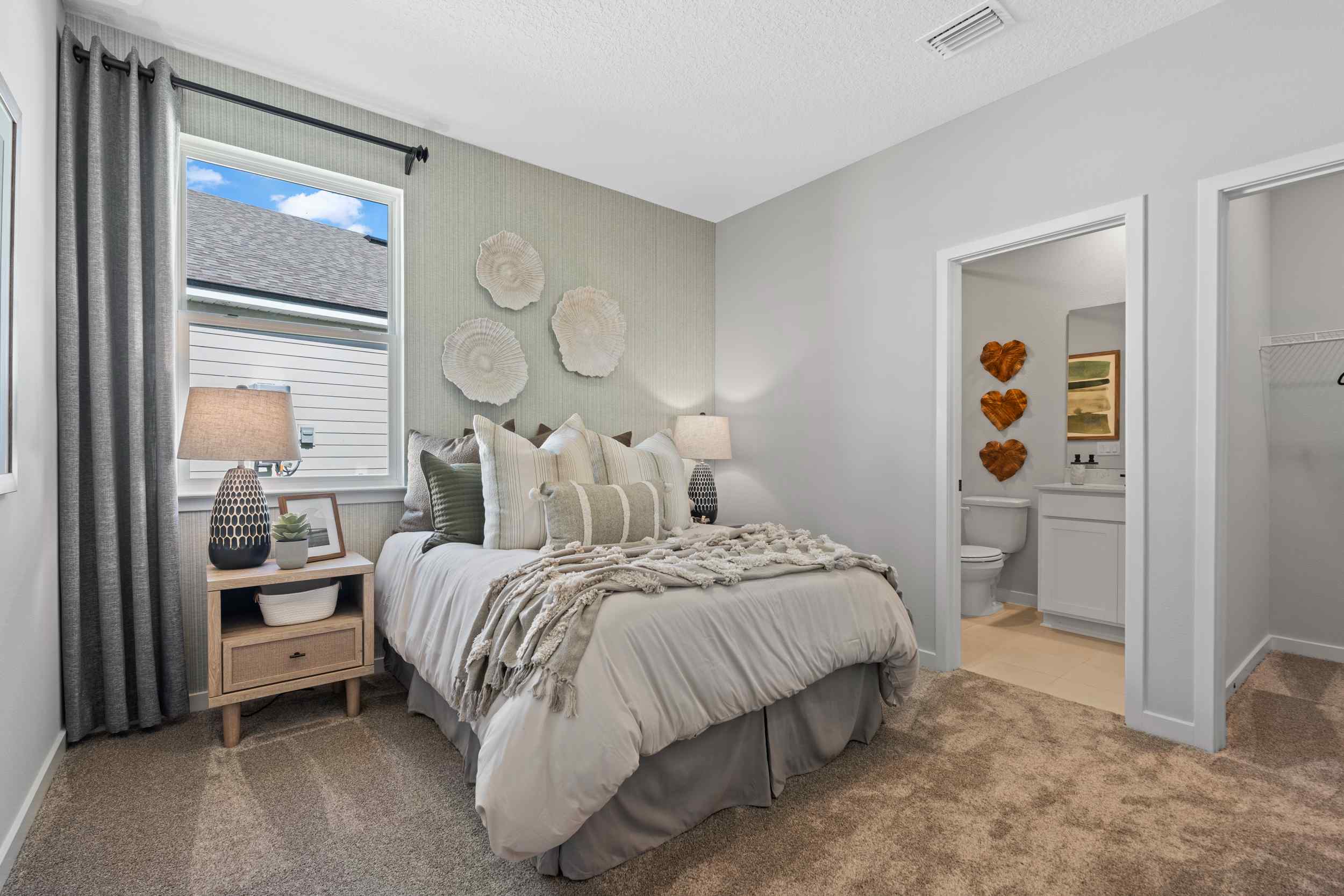 Kenai Model Home Guest Suite with Gray Bed and Attached Bath at Reserve East in Flagler Beach