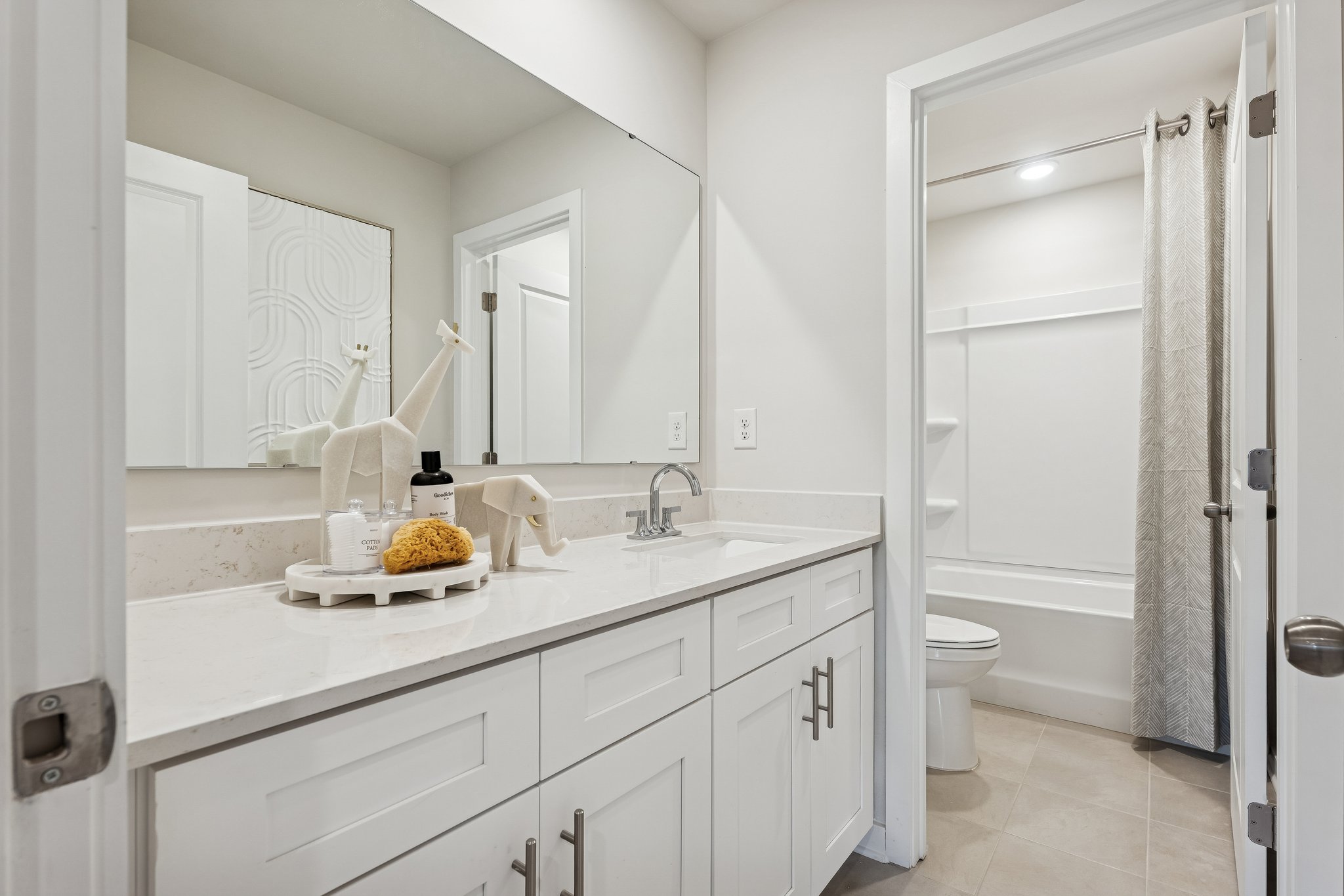 A bathroom with white cabinets.