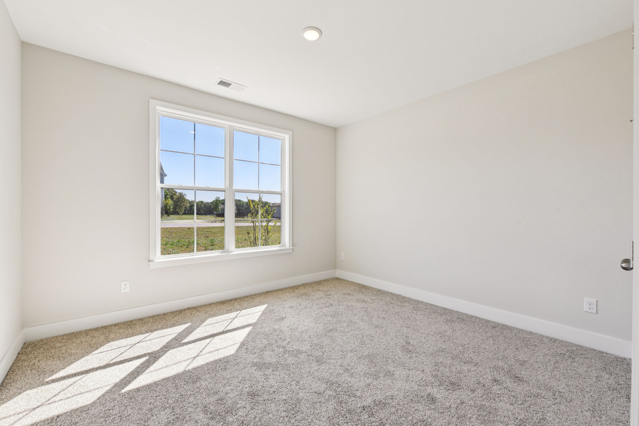 A room with a window and a rug in it.