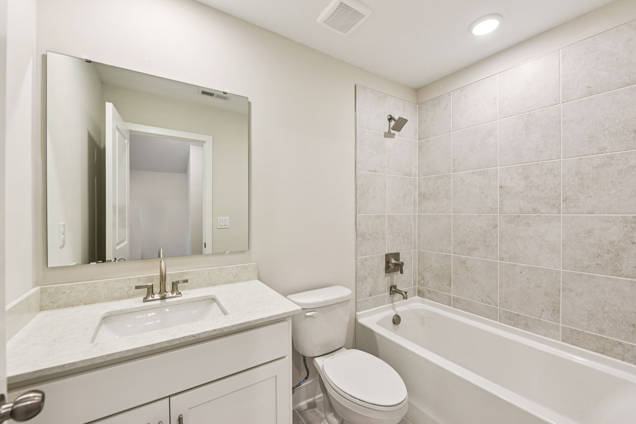 A bathroom with a sink toilet and bathtub.