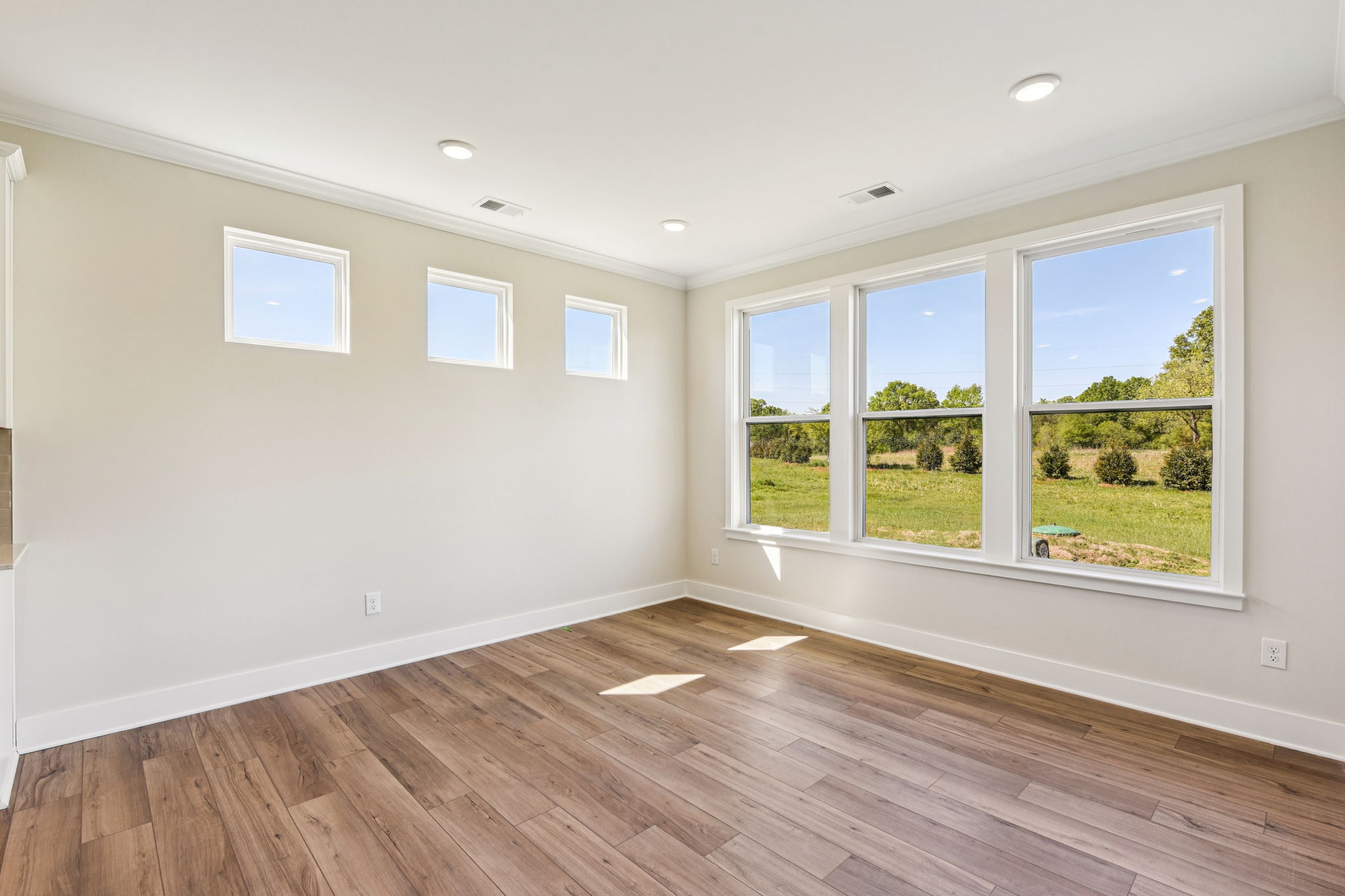 A room with windows and a wood floor.