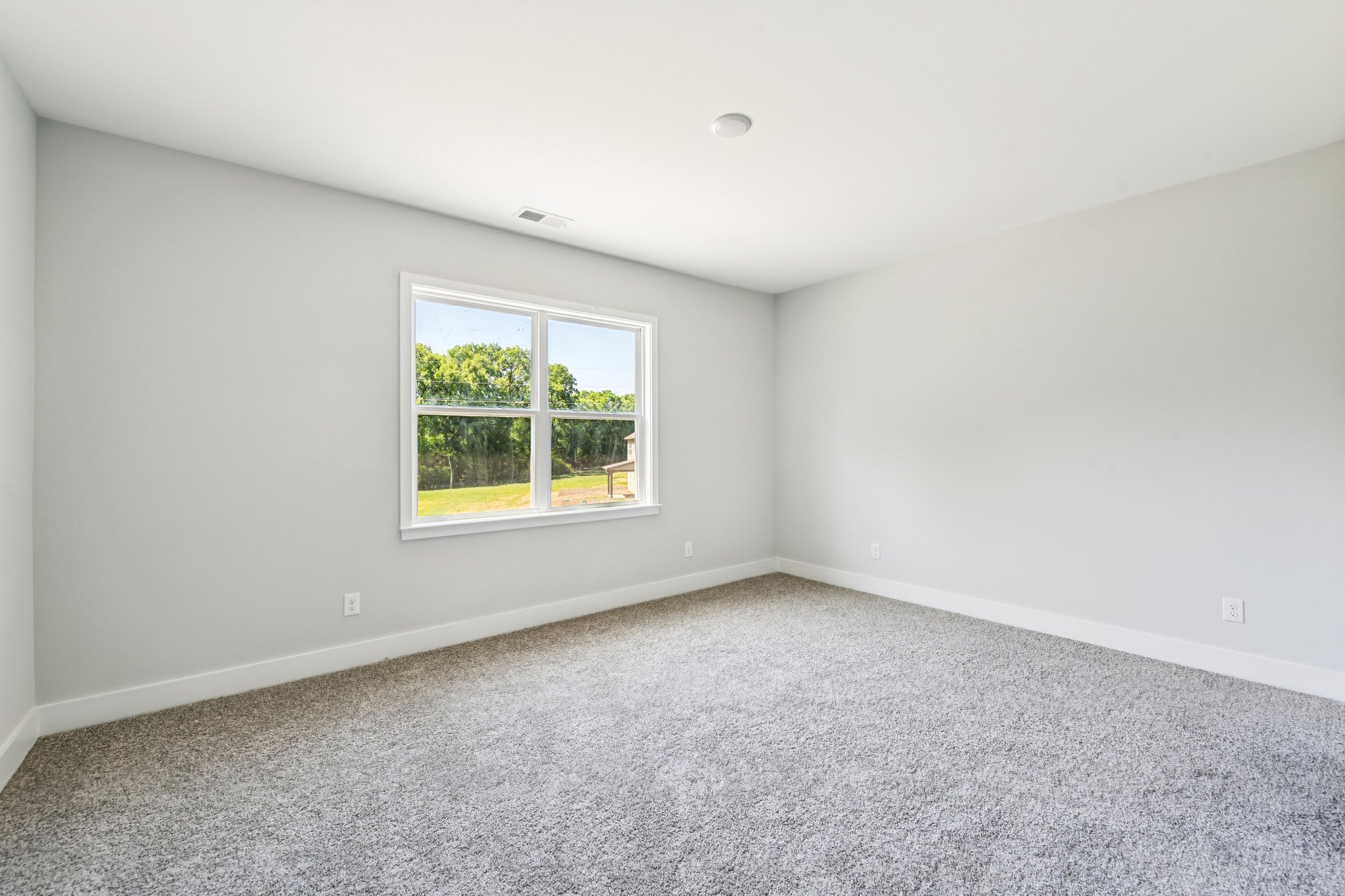 A room with a window and a carpet.