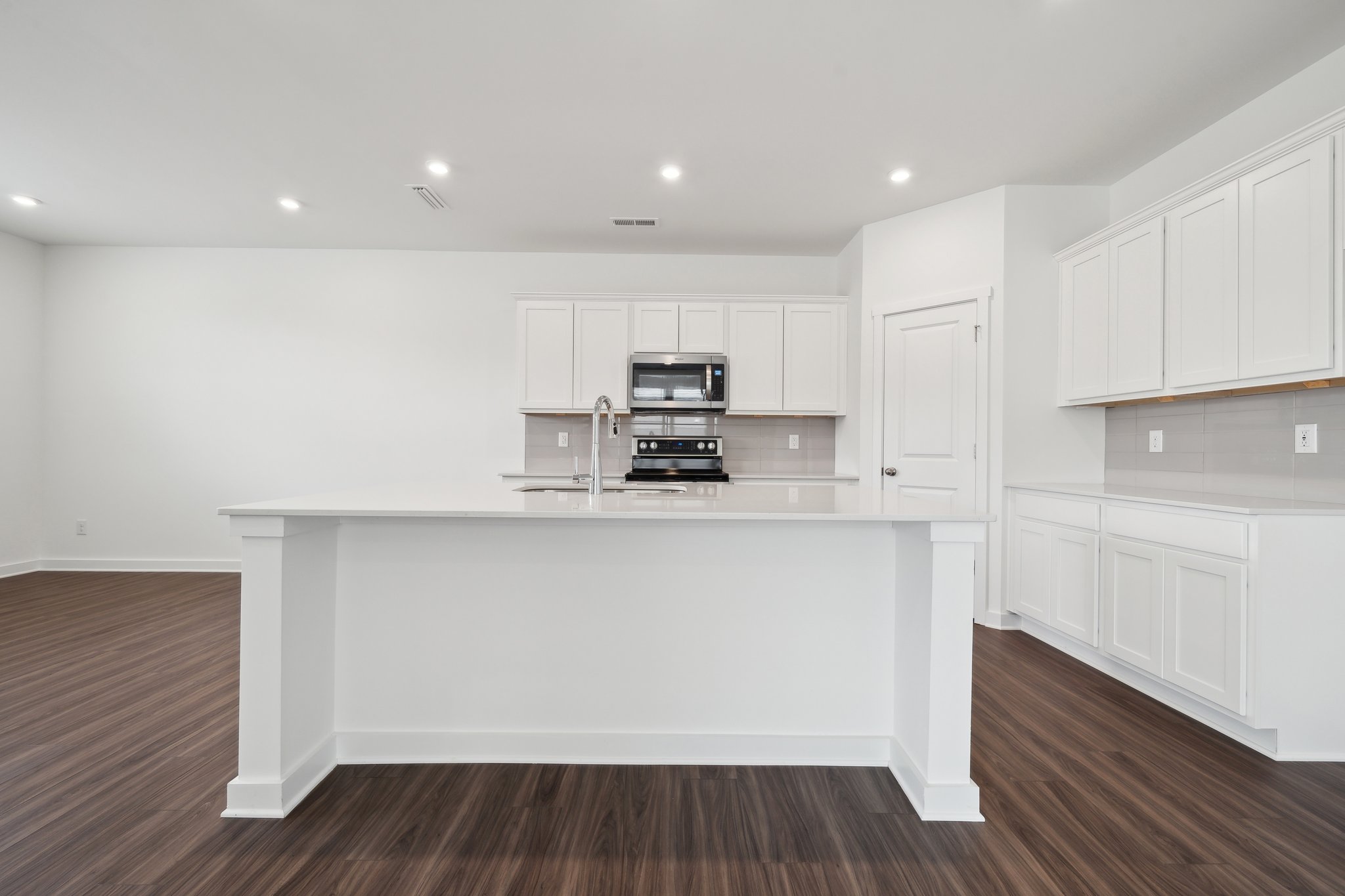 A kitchen with white cabinets.