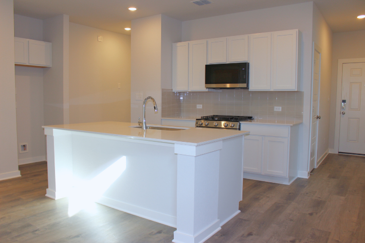 A kitchen with white cabinets.