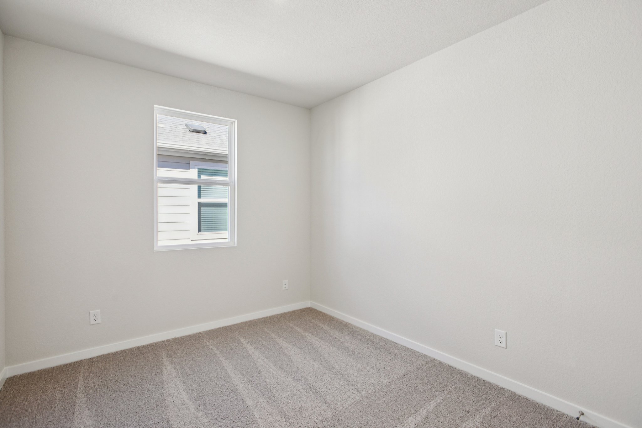 A room with a window and a rug.