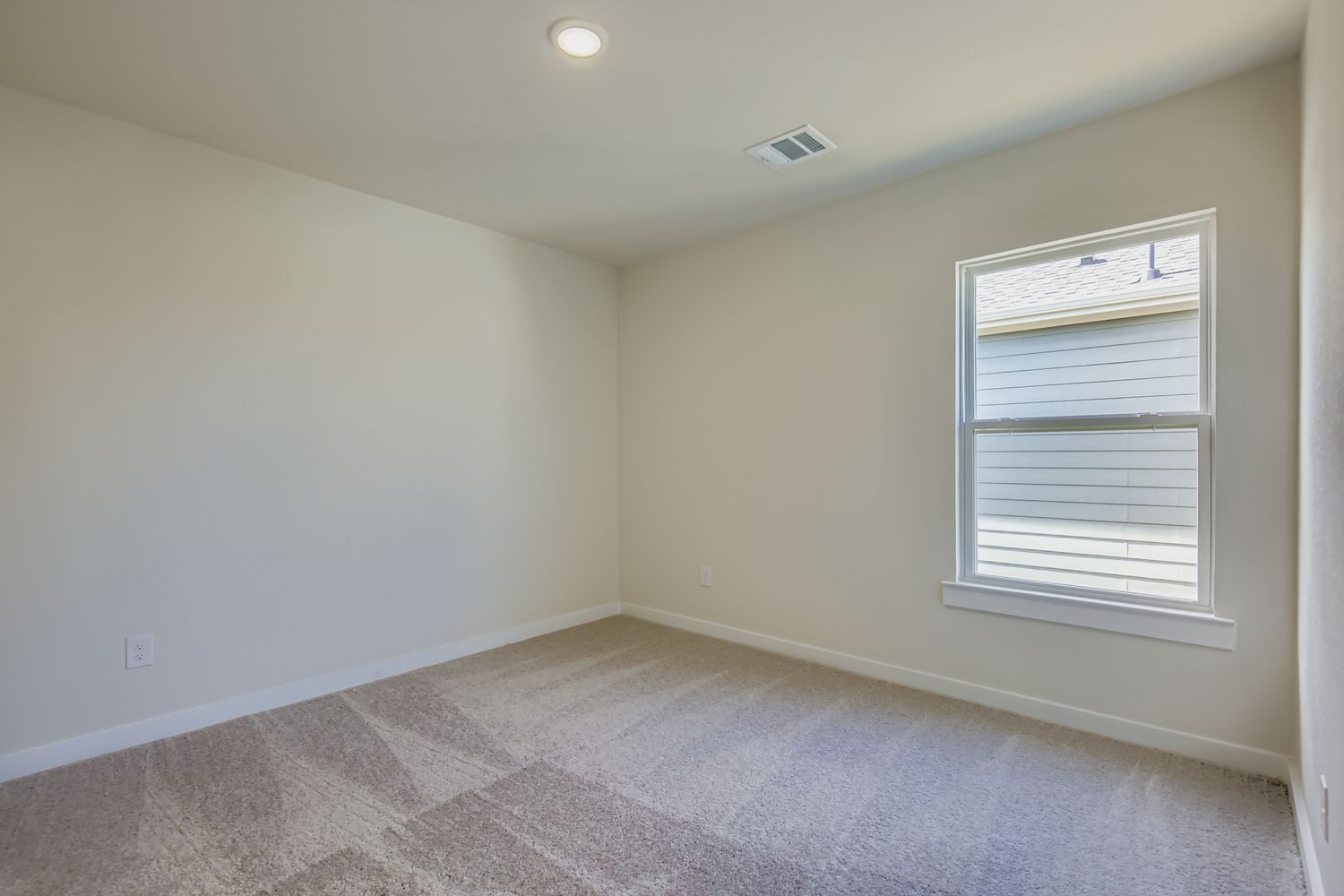 A room with a window and carpet.