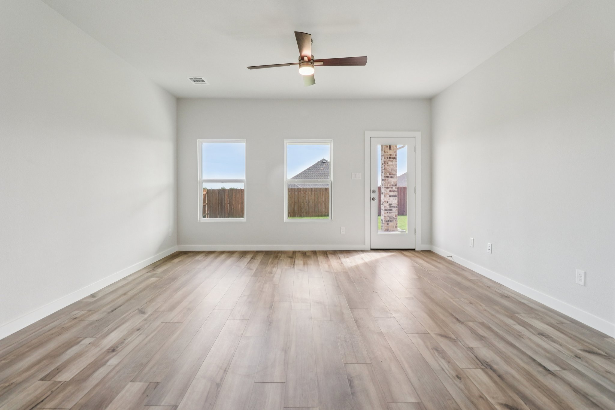 A room with a wood floor and a ceiling fan.