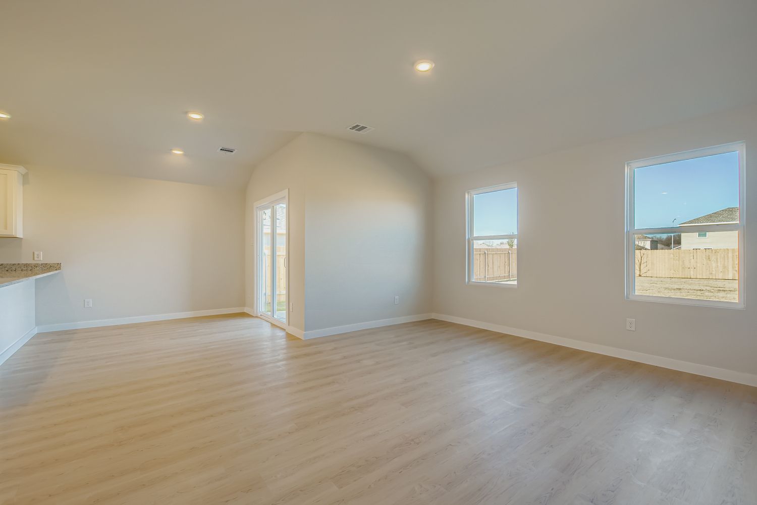 A large empty room with a wood floor and a wood floor.