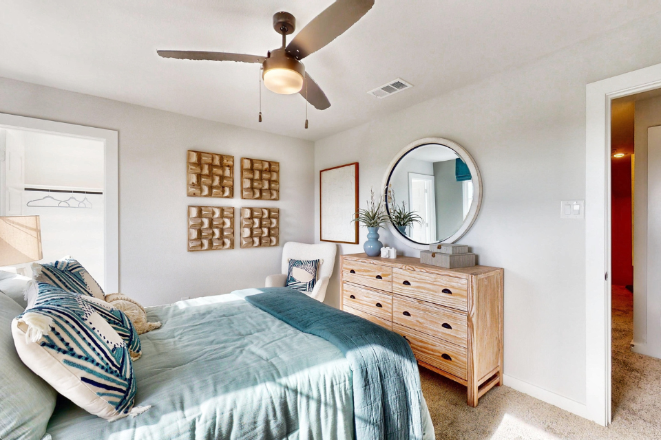 A bedroom with a large mirror.