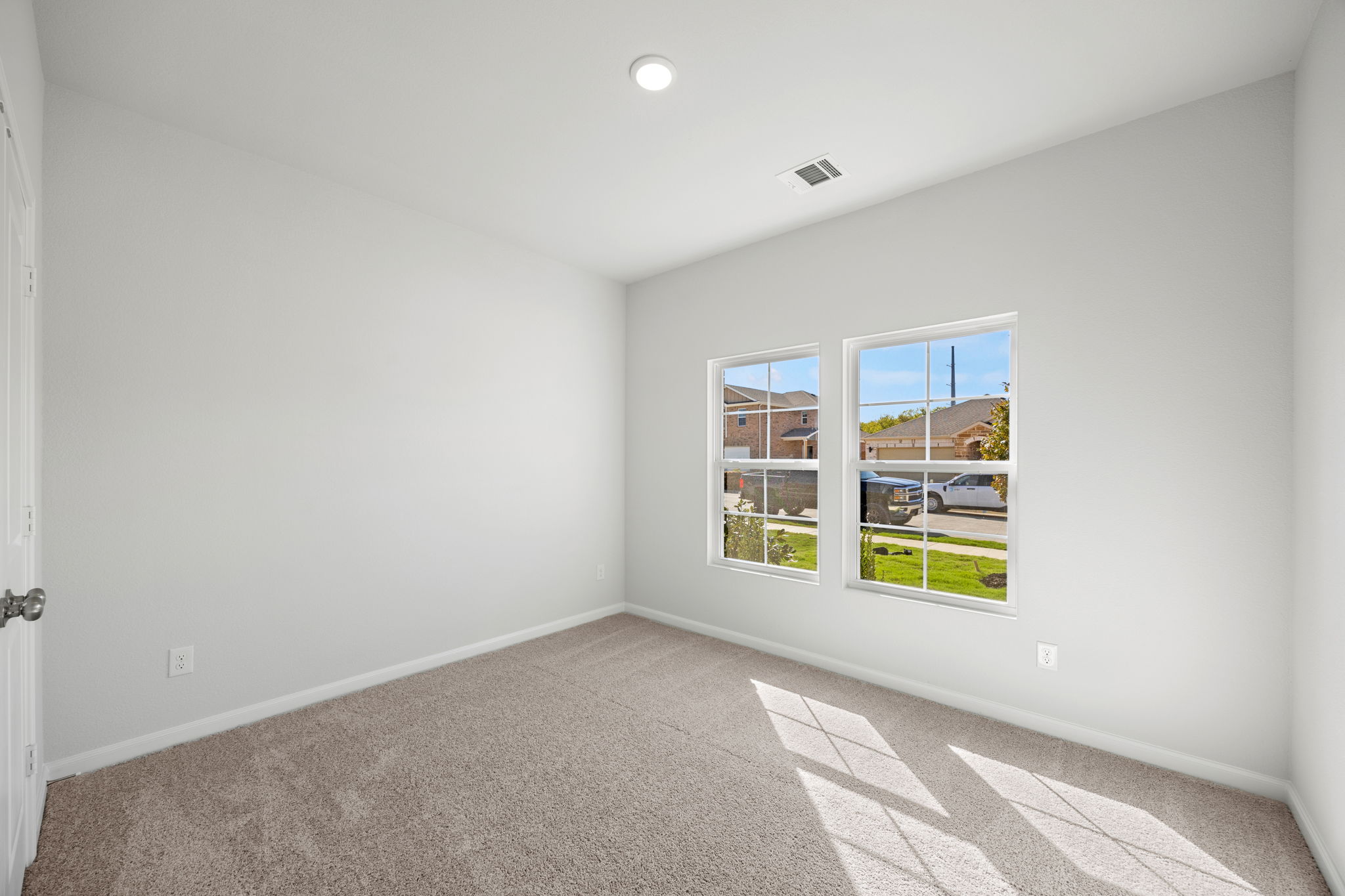 A room with a window and a rug.
