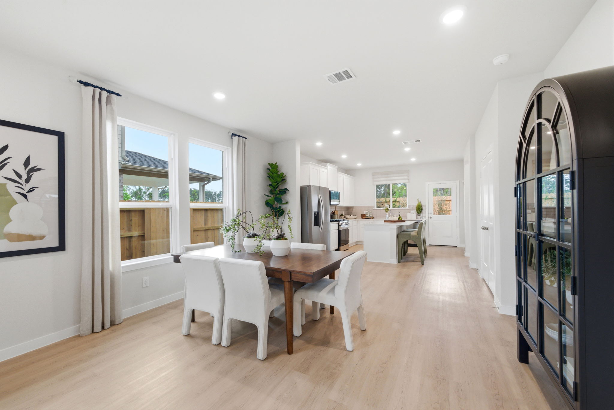 A large dining room with a wood floor.