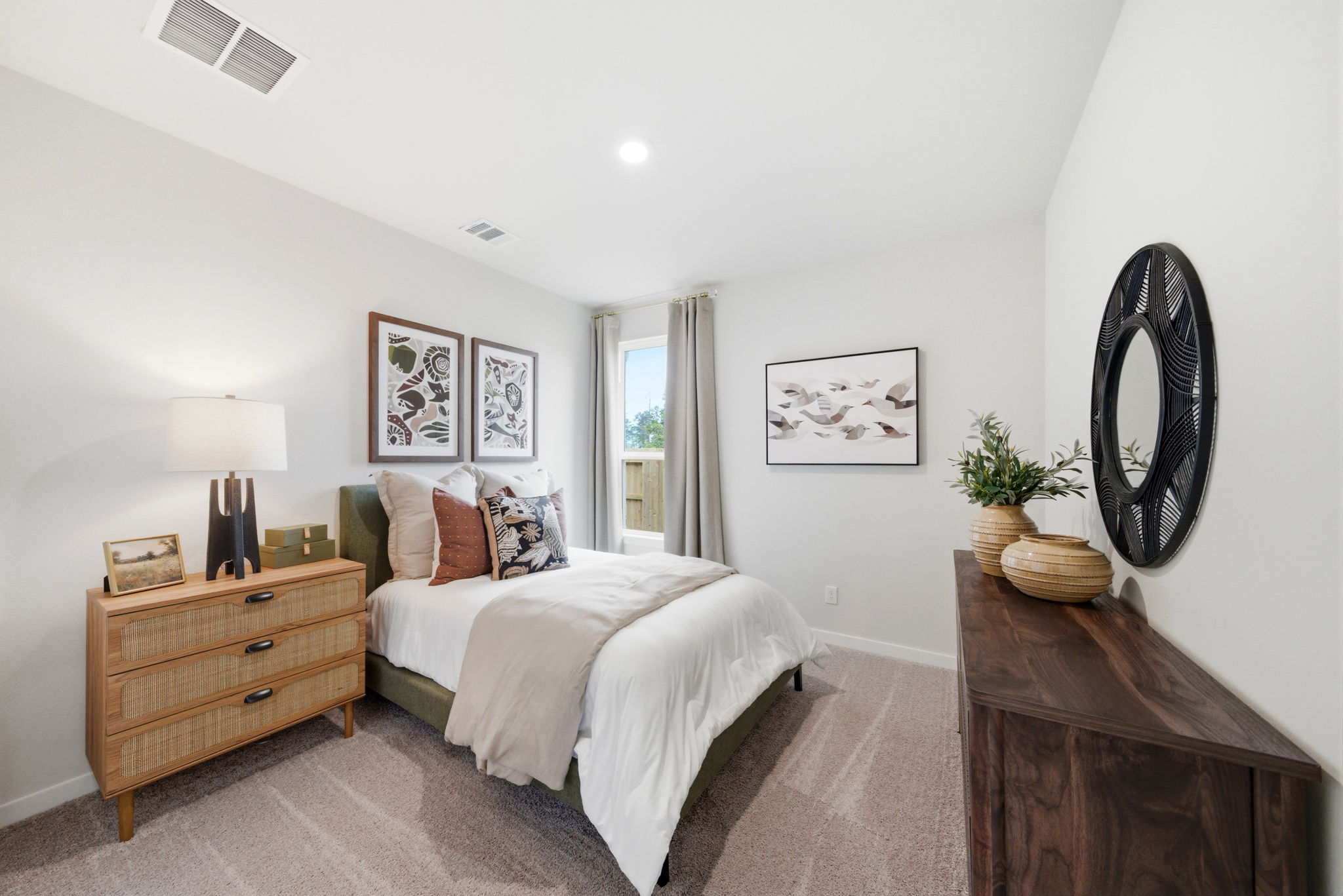 A bedroom with a bed and dresser.