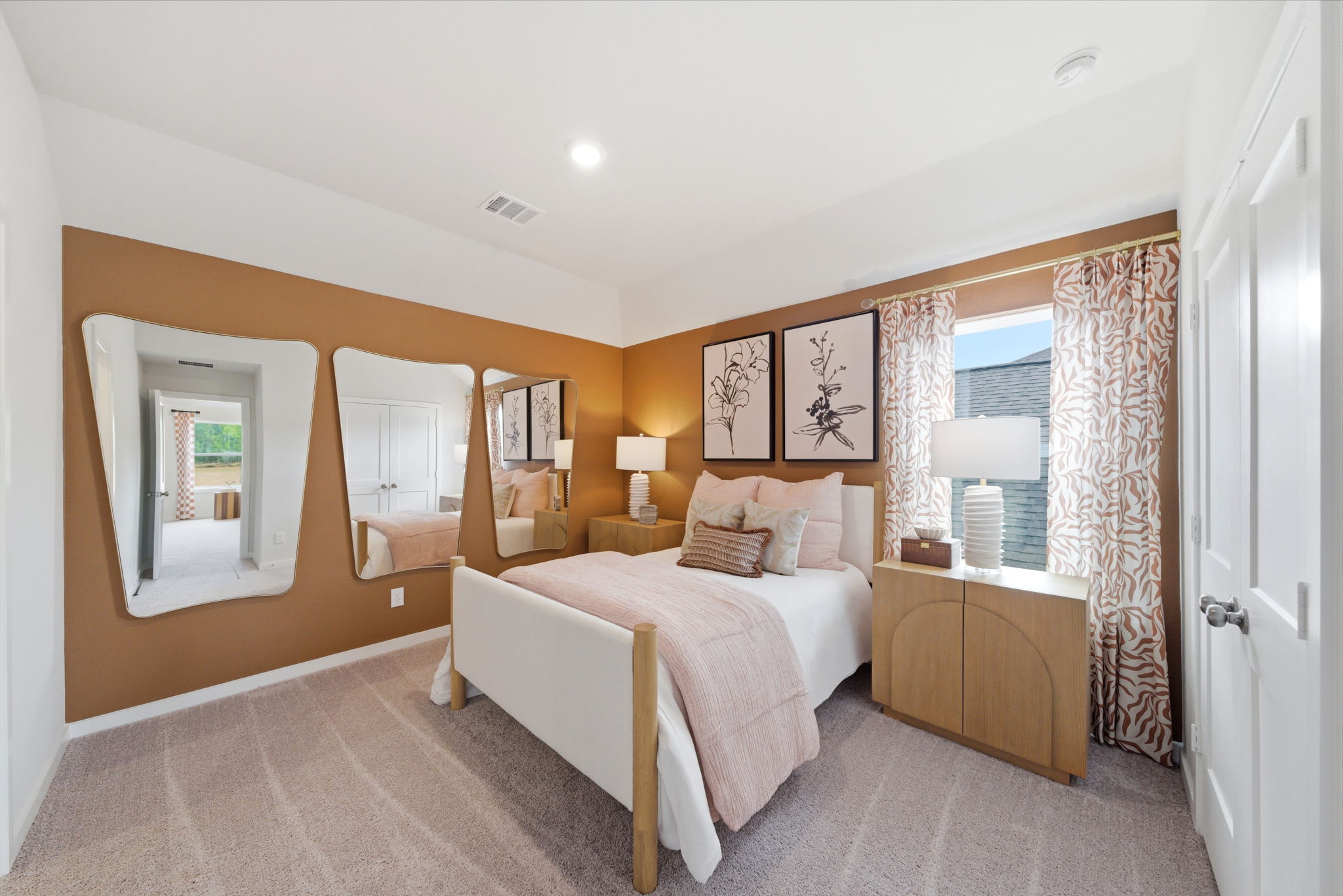 A bedroom with a bed and a mirror.