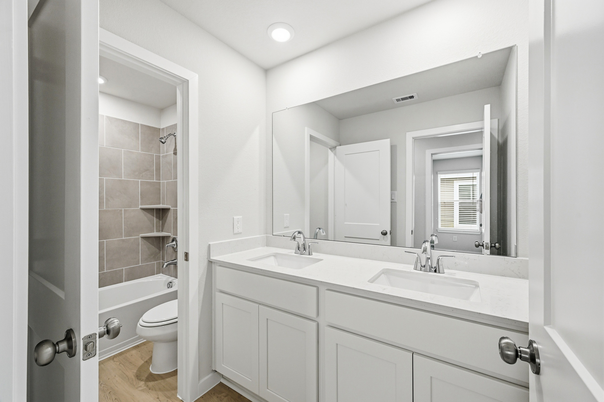 A bathroom with a sink toilet and mirror.