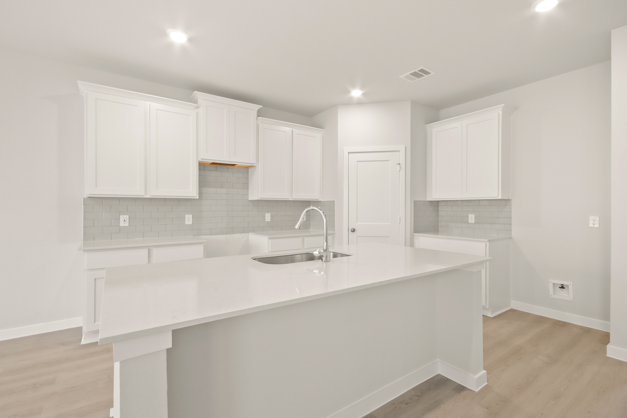 A kitchen with white cabinets.