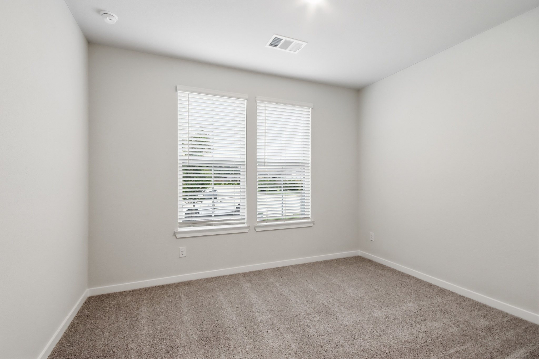 A room with a window and a carpet.