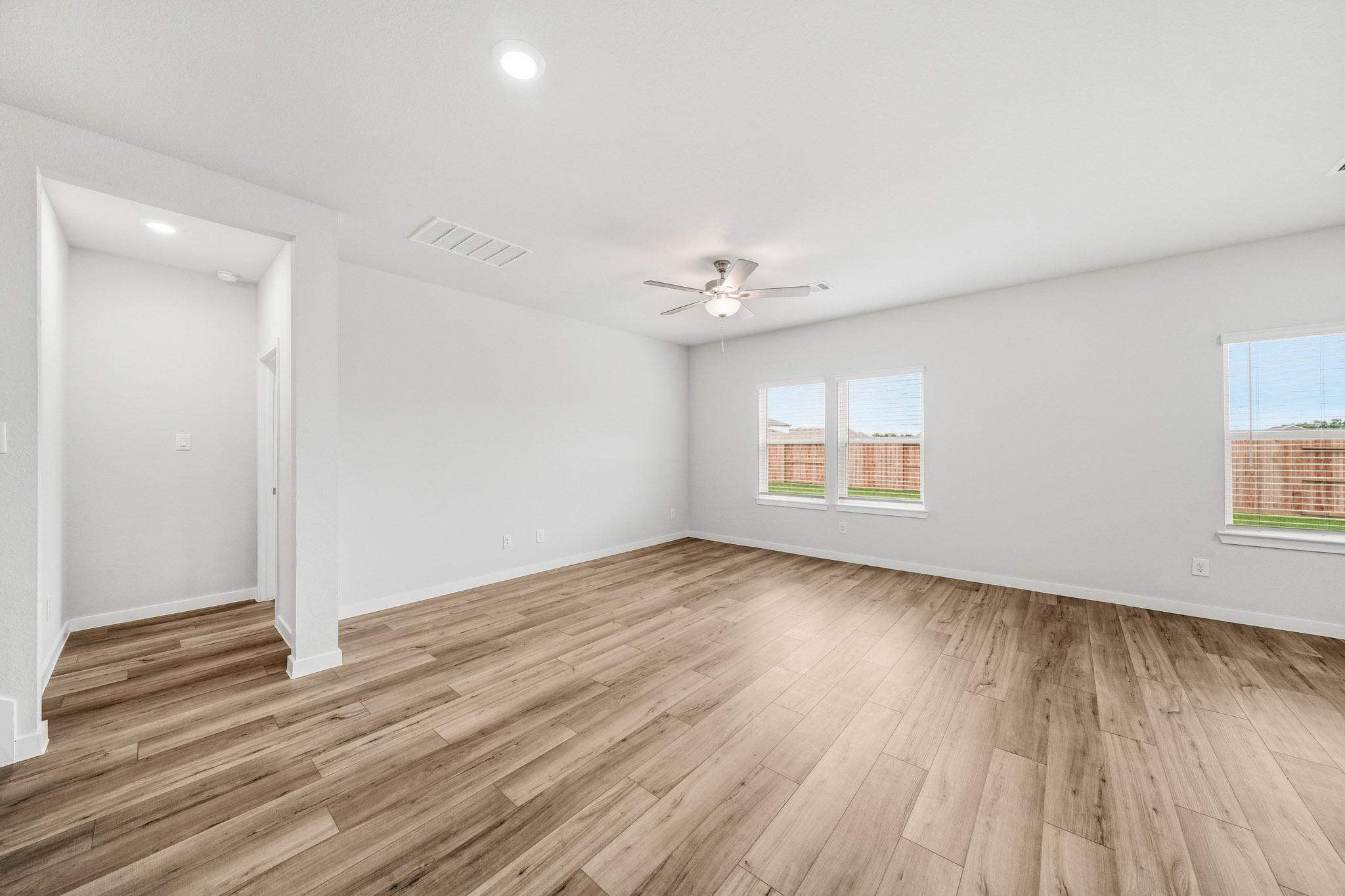 A room with a wood floor and a ceiling fan.