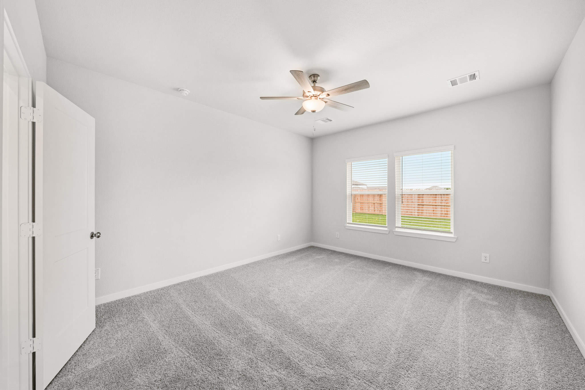 A room with a ceiling fan and a window.