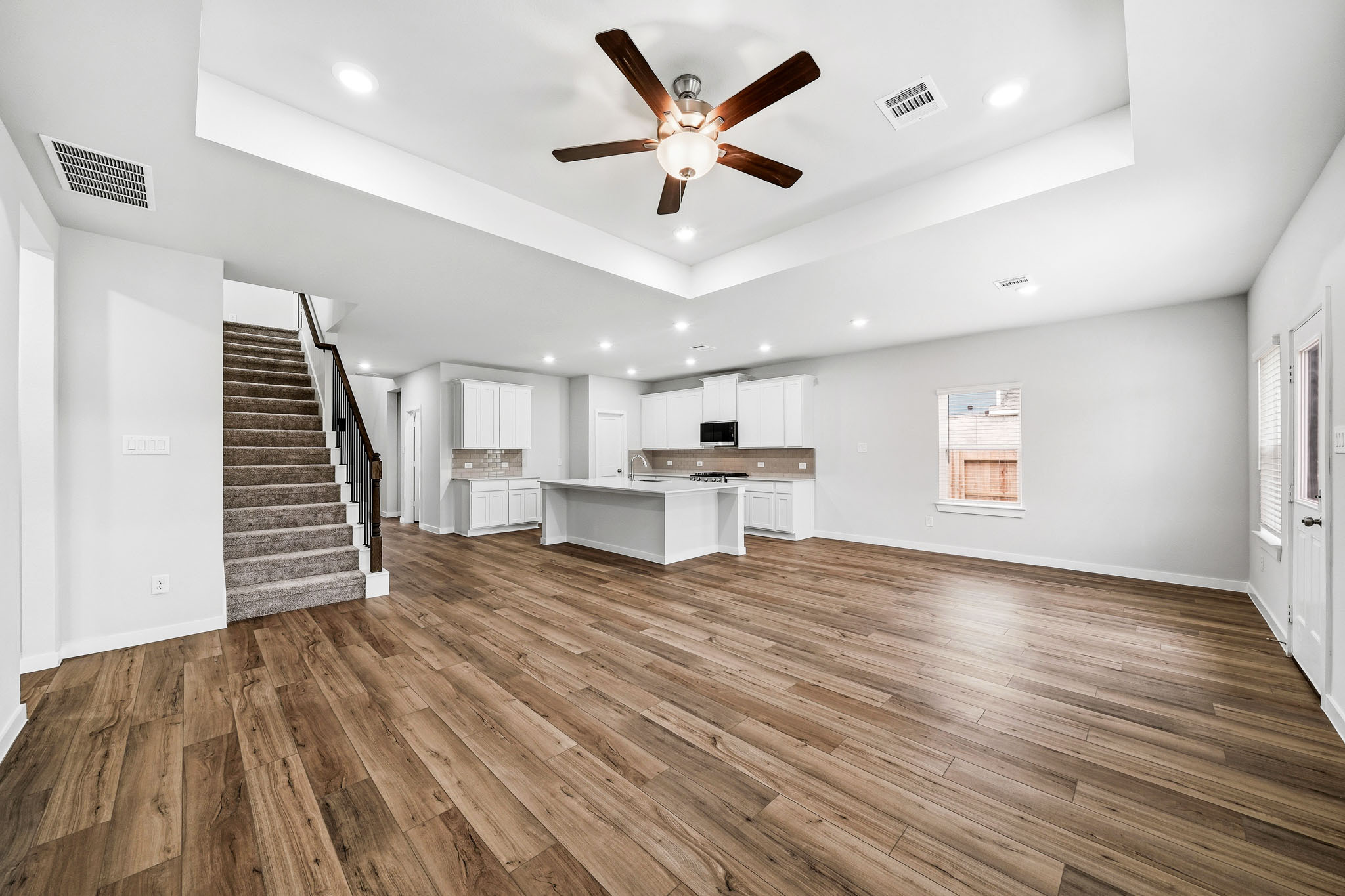 A large empty room with a wood floor and a wood floor.